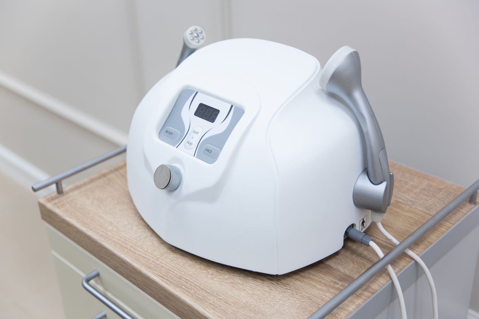 A medical-grade aesthetic laser device on a clinic cart